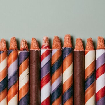 Row of vintage striped bottle rocket fireworks standing against a green background for holiday marketing, seasonal celebration flyers and summer event banners with copy space