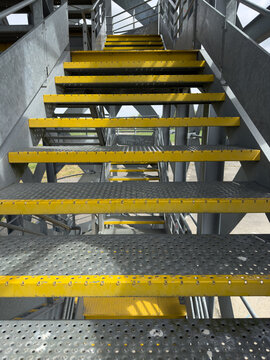 Industrial metal staircase with yellow safety edges