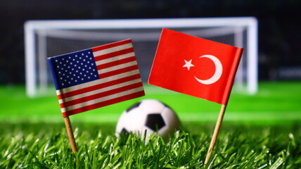 Small flags of the usa and turkey on a soccer field with a ball and goal in the background, representing a football match between the two countries © Photo Agency