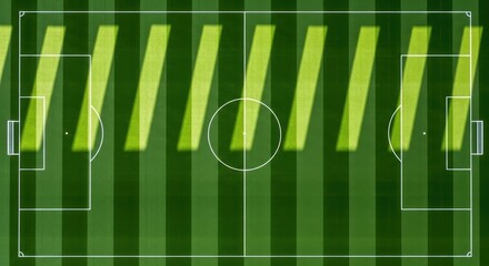 Obraz premium Aerial view of a soccer field with dramatic light and shadow stripes