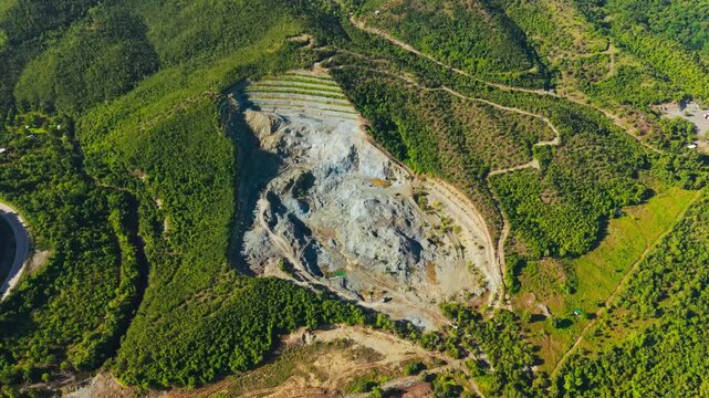 Gray quarry scars lush Palawan hills beside dense tropical rainforest zone