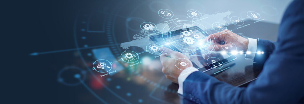 Operator using tablet controlling industrial Automation systems across the world. Smart robotic workflows maximize production efficiency, operational safety, and global resource optimization.