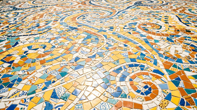 Vibrant ceramic mosaic floor with colorful spiral patterns and geometric tile fragments in blue, yellow, and orange, creating a decorative textured surface.