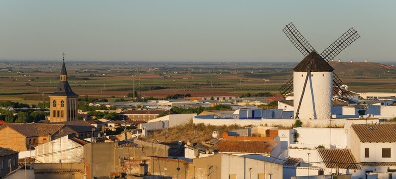 View of a windmill and a village with a church in the morning light, Campo de Criptana, Ciudad Real province, Castilla-La Mancha, Don Quixote Route, Spain