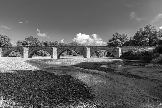 Stone arch bridge, Ponte Buriano, over the river Arno, near Arezzo, black and white photo, Tuscany, Italy
