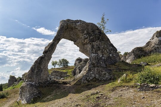 View through rock gate Lergravsporten, limestone formation in Lergravsviken nature reserve, backlight, Gotland Island, Sweden