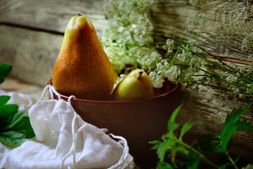 Conference pears. Still life featuring bowl with sweet pears,  autumn atmospheric mood, flowers and fruits. Harvesting, village, countryside © ElenaEmiliya