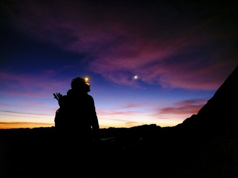 Silhouette of a female mountaineer with headlamp at dawn, Hoher G&ouml;ll, Berchtesgaden Alps, Berchtesgaden National Park, Sch&ouml;nau am K&ouml;nigssee, Berchtesgadener Land, Upper Bavaria, Bavaria, Germany