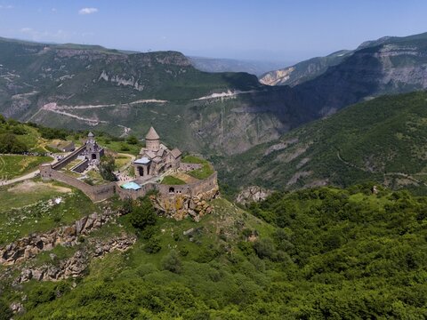 A monastery embedded in a green mountain landscape under a blue sky, aerial view, Tatev Monastery, Tatev, Armenian Apostolic Monastery, Syunik Province, Syunik, Armenia