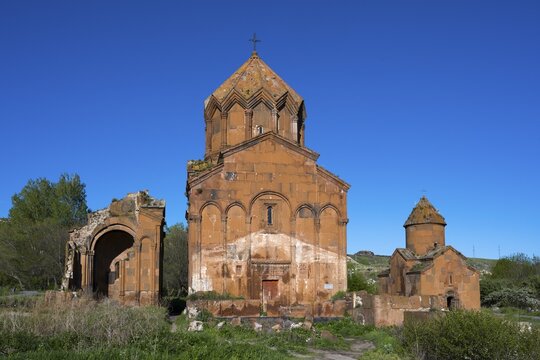 Historic brick church under a clear sky, surrounded by vegetation, cross-domed church, Marmashen Monastery, Marmashen Vank, Shirak Province, Armenia