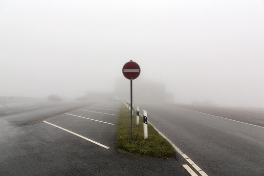 Empty car park at K&ouml;terberghaus with one-way street sign, dreary autumn weather with fog, mountain peak, K&ouml;terberg, L&uuml;gde, Weserbergland, North Rhine-Westphalia, Germany