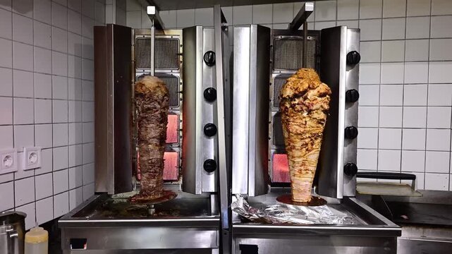 Doner kebab meat cooking on a vertical rotisserie machine