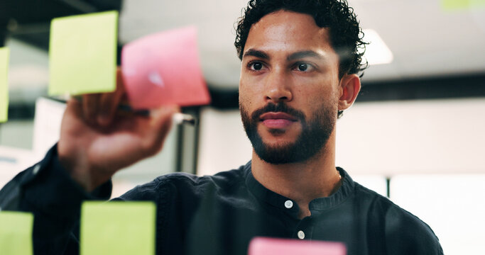 Business, man and writing on sticky notes in office for function details, guest list or schedule. Event coordinator, planning or brainstorm on glass for vendor ideas, calendar and project management