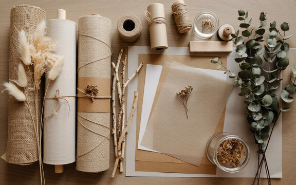 Burlap rolls twine dried flowers and paper in a flat lay composition
