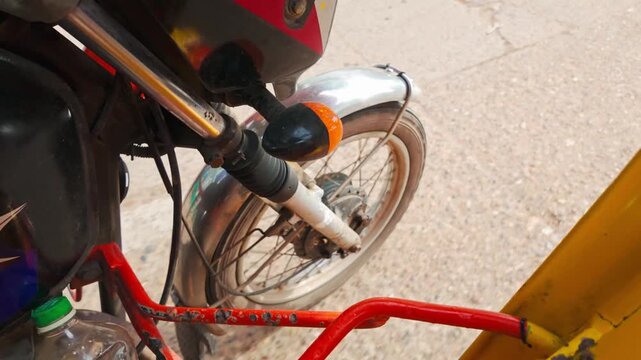 Close perspective of a tricycle wheel rolling through sunny Philippine streets