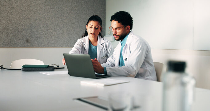Doctors, team and laptop with review at hospital in boardroom, meeting and planning for healthcare. People, medical professional and insight with computer, feedback or services at wellness clinic