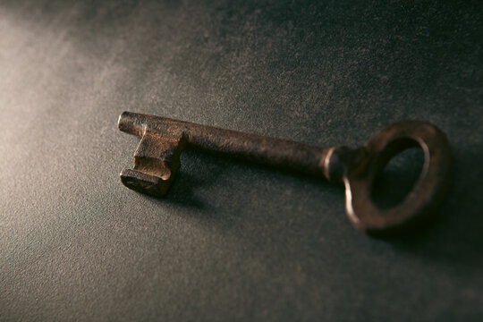 Old key on a black background. Selective focus. Toned.