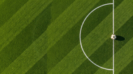Obraz premium Aerial view of a soccer ball resting on the line of a green grass field, generated using ai