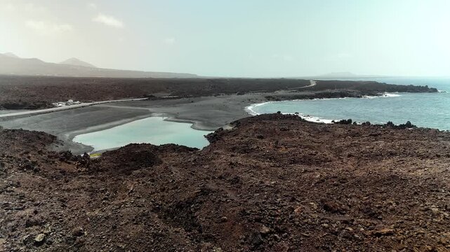 Aerial drone flight over volcanic coastline and Charco de los Clicos, Lanzarote