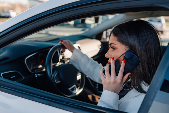 Woman driving car talking on smartphone dangerously