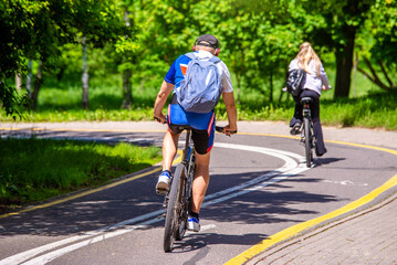 Naklejka premium Cyclists ride on the bike path in the city Park 