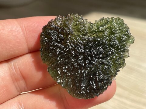 A perfect green Moldavite Heart with deep sculpting 
