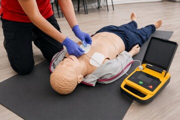Naklejka premium CPR Training with Defibrillator on Mannequin