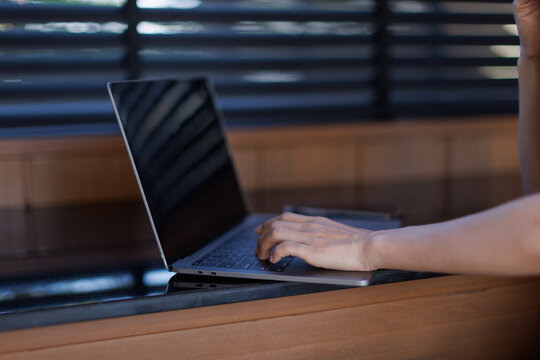 Person typing on a laptop computer, working remotely from a home office, engaging in online communication, digital tasks, and productivity for business or studying