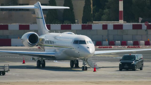 Private jet waiting for passengers at airport terminal. Transportation and air travel by business jets, small planes
