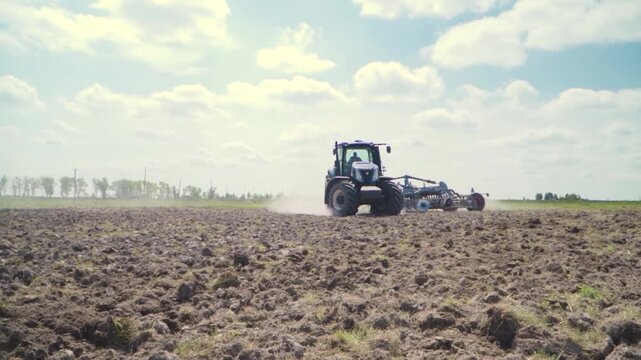 Blue Tractor Cultivating Agricultural Field on Rural Farmland