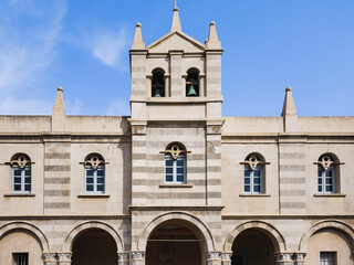 Fototapeta premium Tropea, Italy - April 17, 2026: Architectural detail of the facade and bell tower of Santuario di Santa Maria dell’Isola. The image highlights decorative windows, arches and architecturalal details