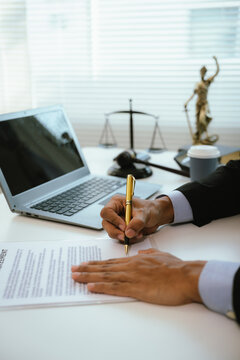 A lawyer reviews and signs legal documents at a modern office desk, symbolizing contract agreements, legal consultation, compliance, business law, and professional legal services.