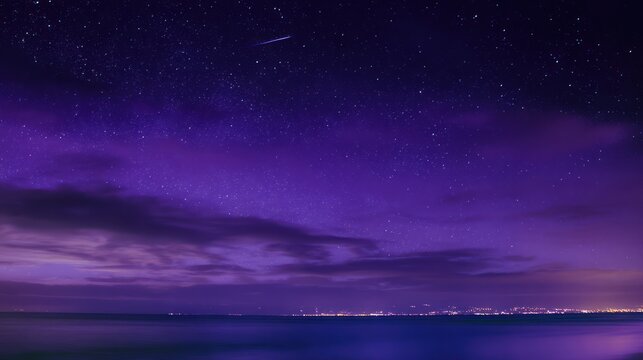 Purple nightscape with stars over ocean, blurred clouds, and a faint meteor shower