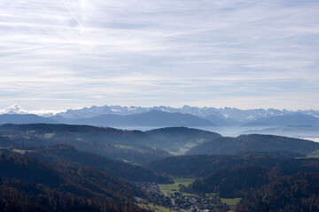 Fototapeta premium Aerial view from local mountain Uetliberg with valley and Swiss Alps in the background on an autumn day. Photo taken October 29th, 2025, Zurich Uetliberg, Switzerland.