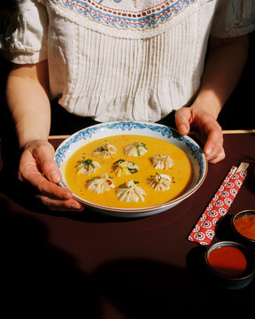 Woman holding a bowl of delicious dumpling Hymalayan soup