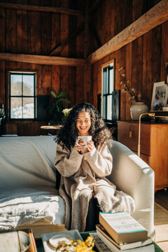 Woman enjoying cozy coffee moment in rustic cabin