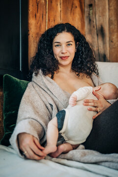 Portrait of mother breastfeeding baby in a cozy home setting