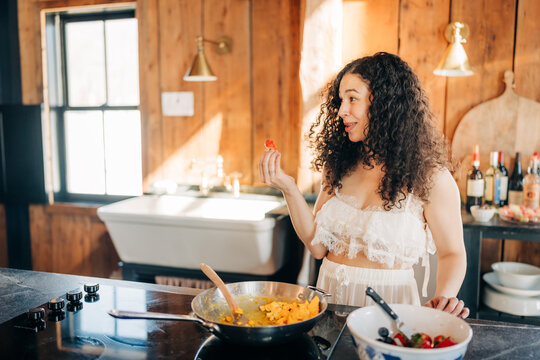 Woman preparing breakfast with fresh ingredients in kitchen