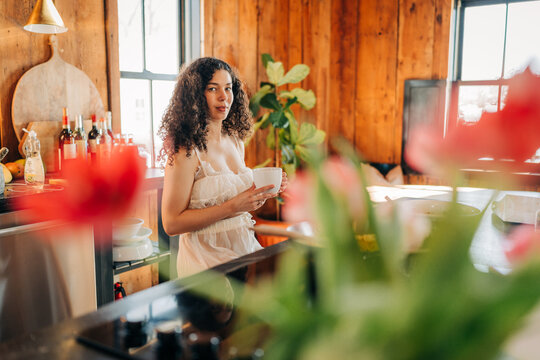 Woman enjoying morning coffee in rustic kitchen