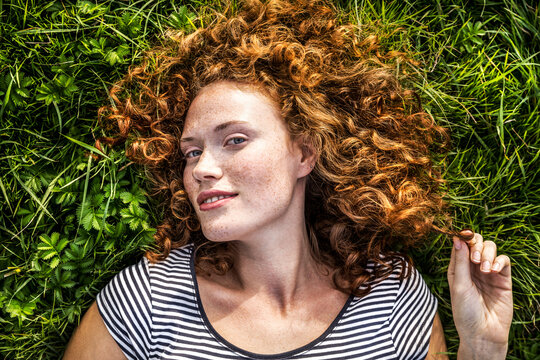Portrait of smiling young woman lying on a meadow