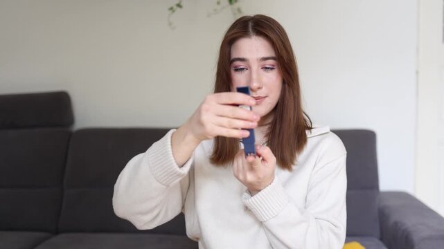 Young woman performs routine blood sugar check using finger prick device monitoring glucose levels for diabetes management preventive healthcare and daily self care