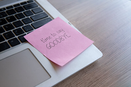 A sticky note reading time to say GOODBYE on a laptop keyboard. Corporate resignation, career transitions, employee termination, quitting a job, and leaving the workplace concept.