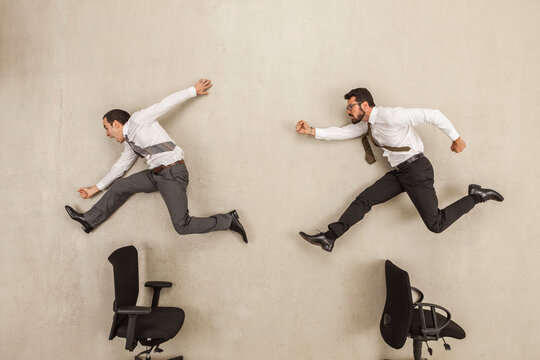 Businessmen chasing against beige background