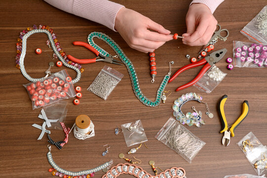Young woman working on self-made jewelry