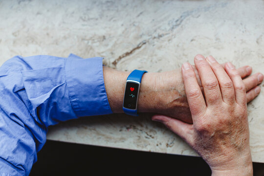 Senior woman with heart shaped symbol on fitness tracker