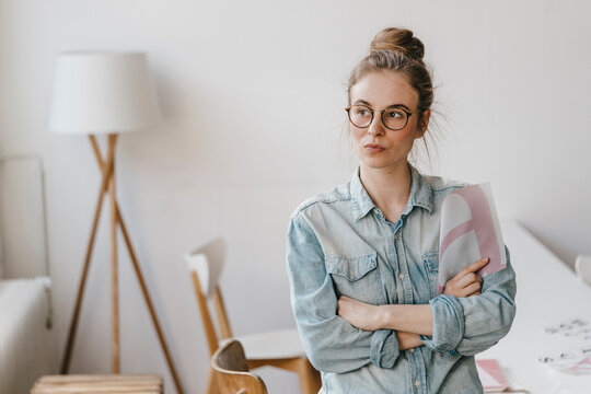 Young woman holding letter template looking sideways