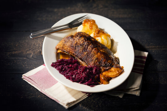 Plate of fried goose breast, red cabbage and potato dumplings