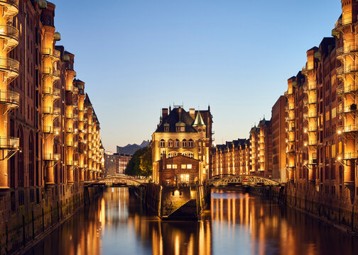 Germany, Hamburg, Speicherstadt, lighted old buildings with Elbe Philharmonic Hall in the background