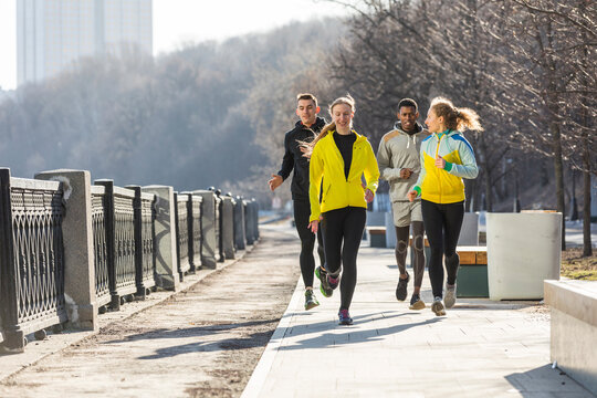 Friends running on promenade in the city