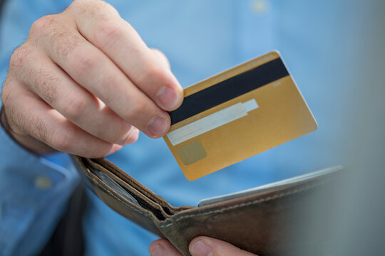 Man's hands holding credit card and purse, close-up